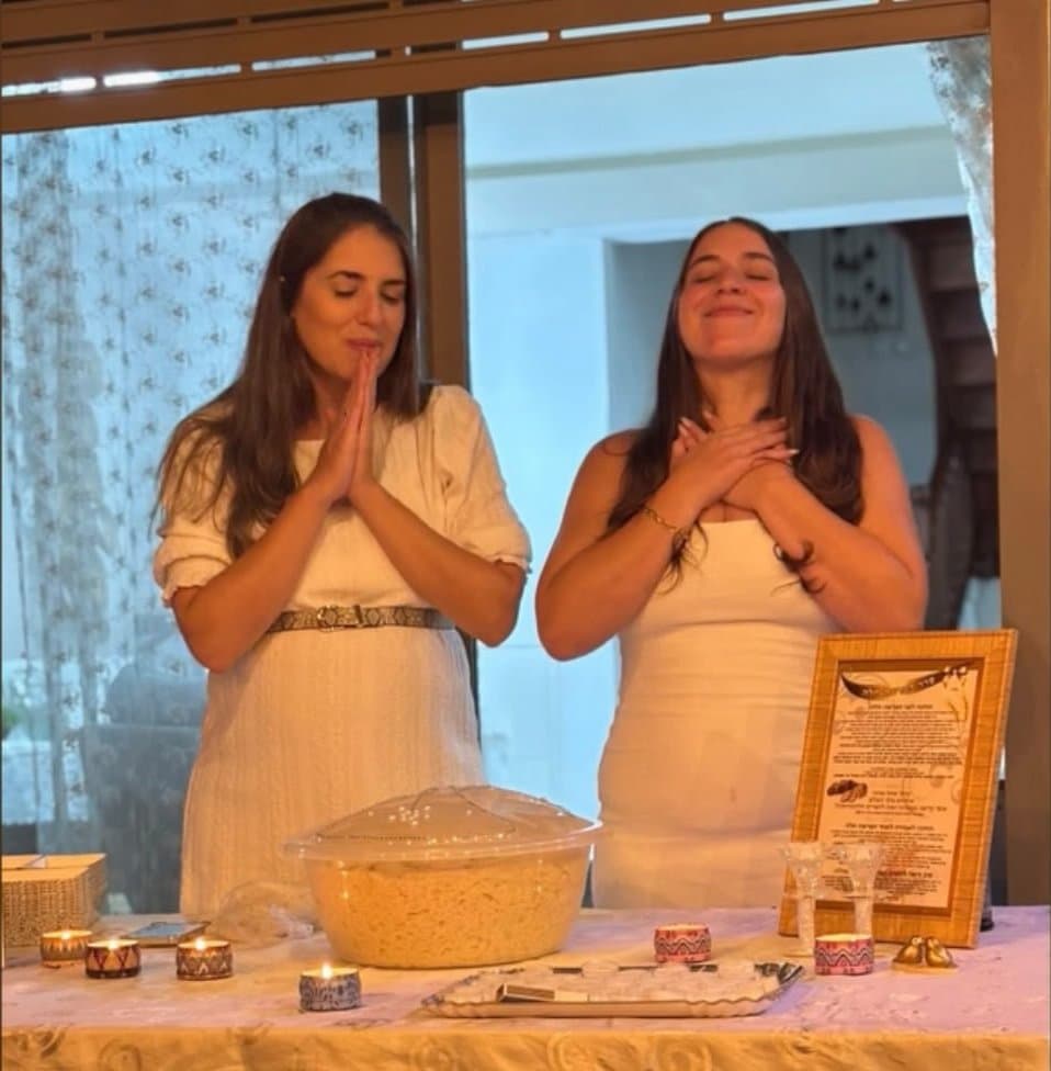 שתי משתתפות מברכות בערב הפרשת חלה לצד קערת הבצק